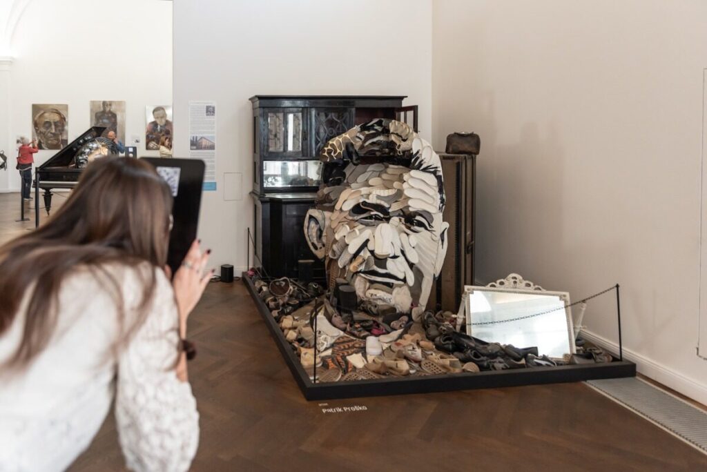 A visitor photographing Patrik Proško’s anamorphic portrait of Tomáš Baťa at Illusion Art Museum Prague (Photo: IAM (Patrik Proško, Tomáš Baťa))