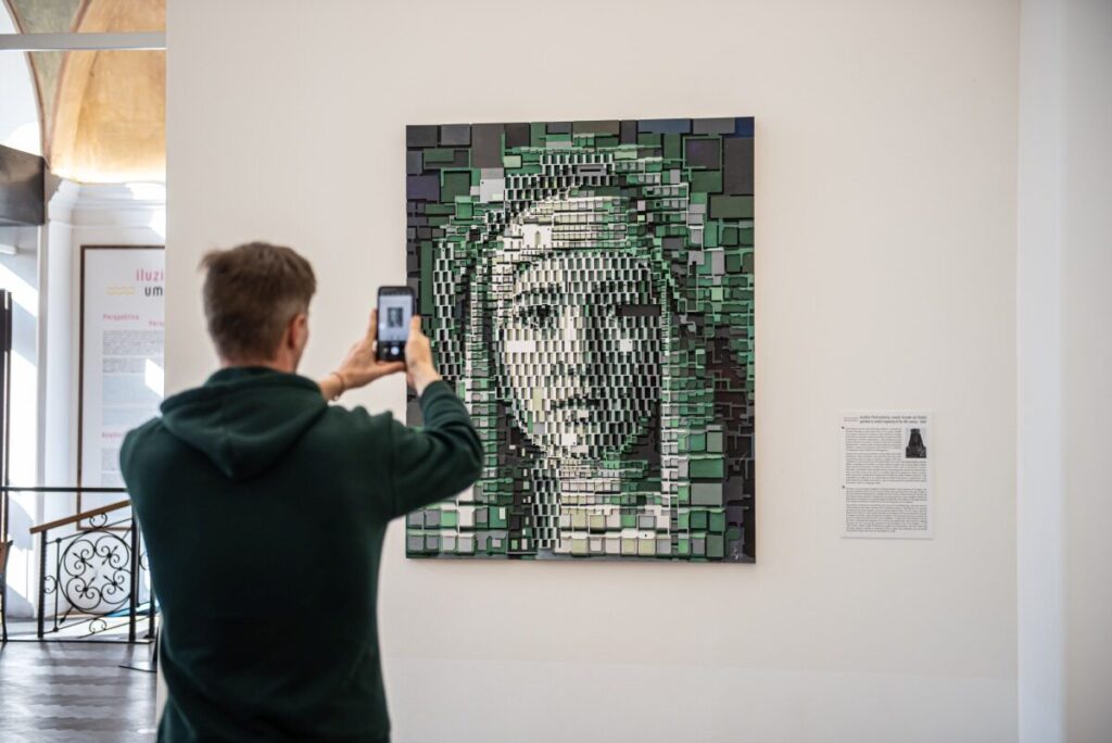 A visitor photographing a portrait by Ivana Štenclová at Illusion Art Museum Prague (Photo: IAM (Ivana Štenclová))
