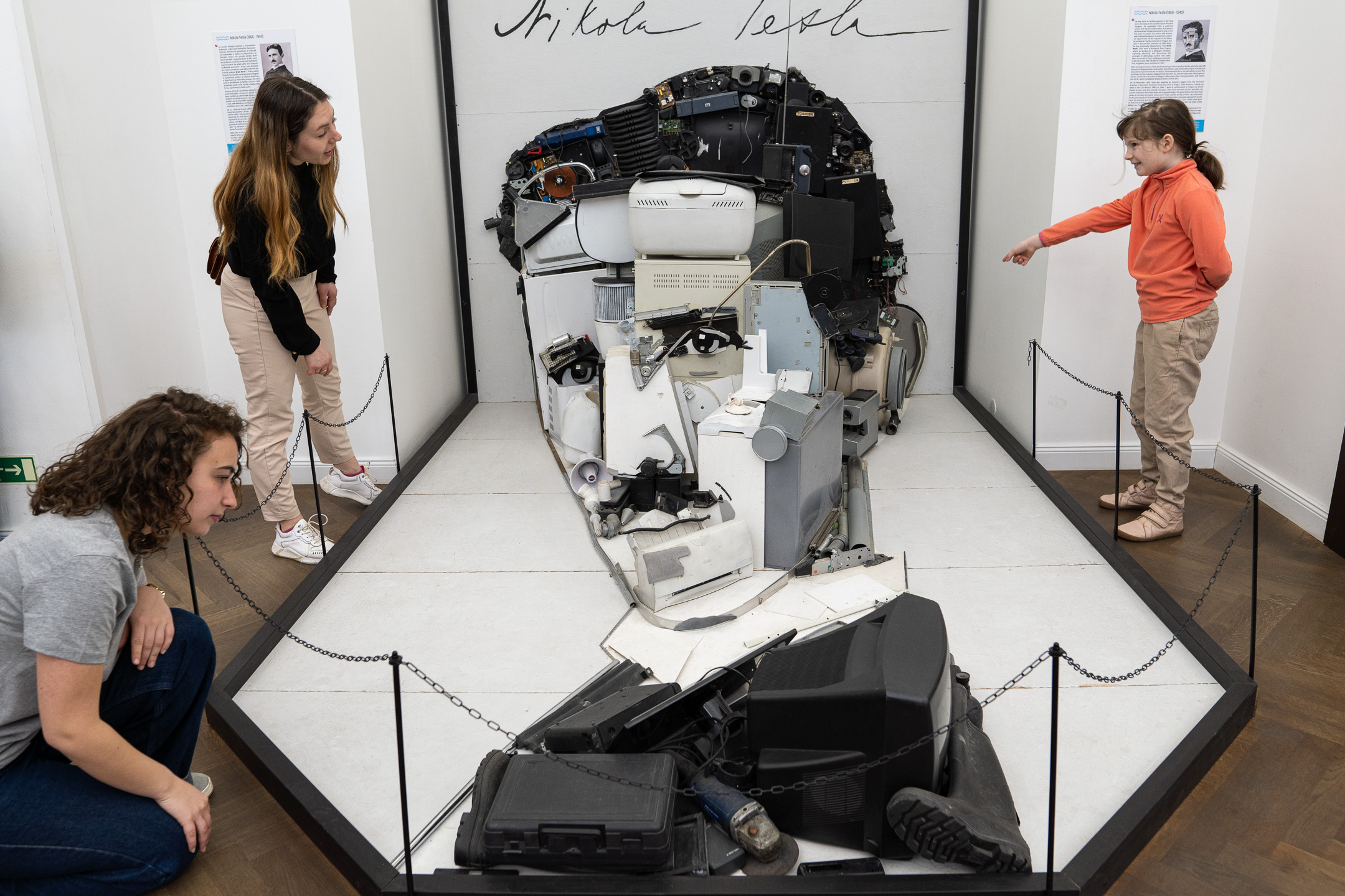 Family explores a Tesla portrait assembled from discarded appliances